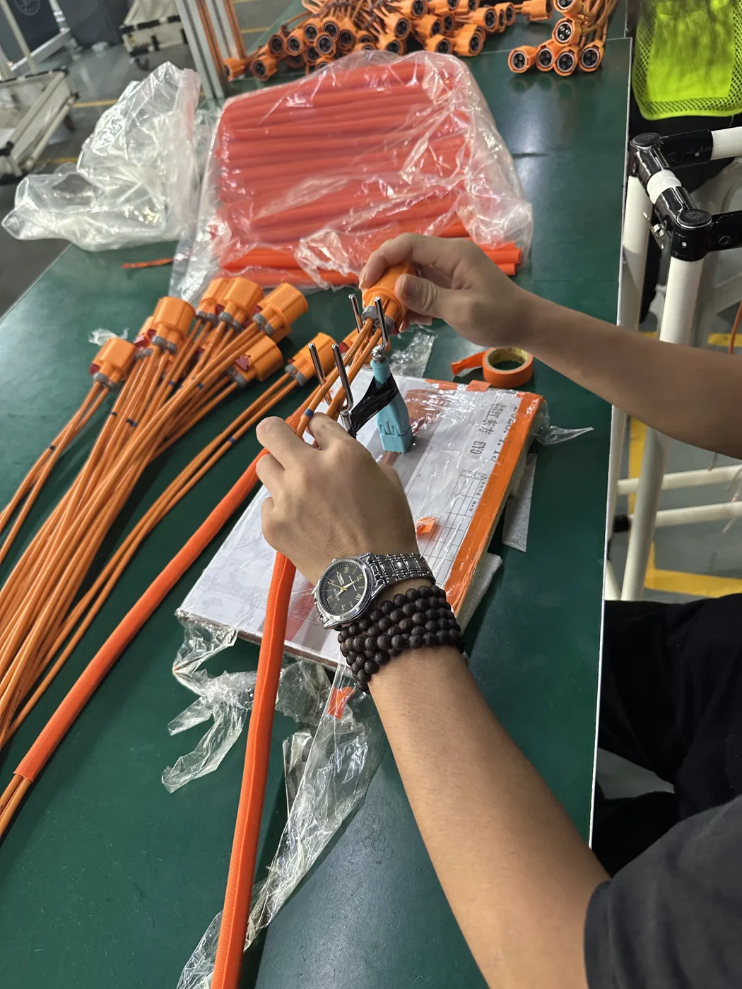 Operator completing connector assembly on finished cable sets
