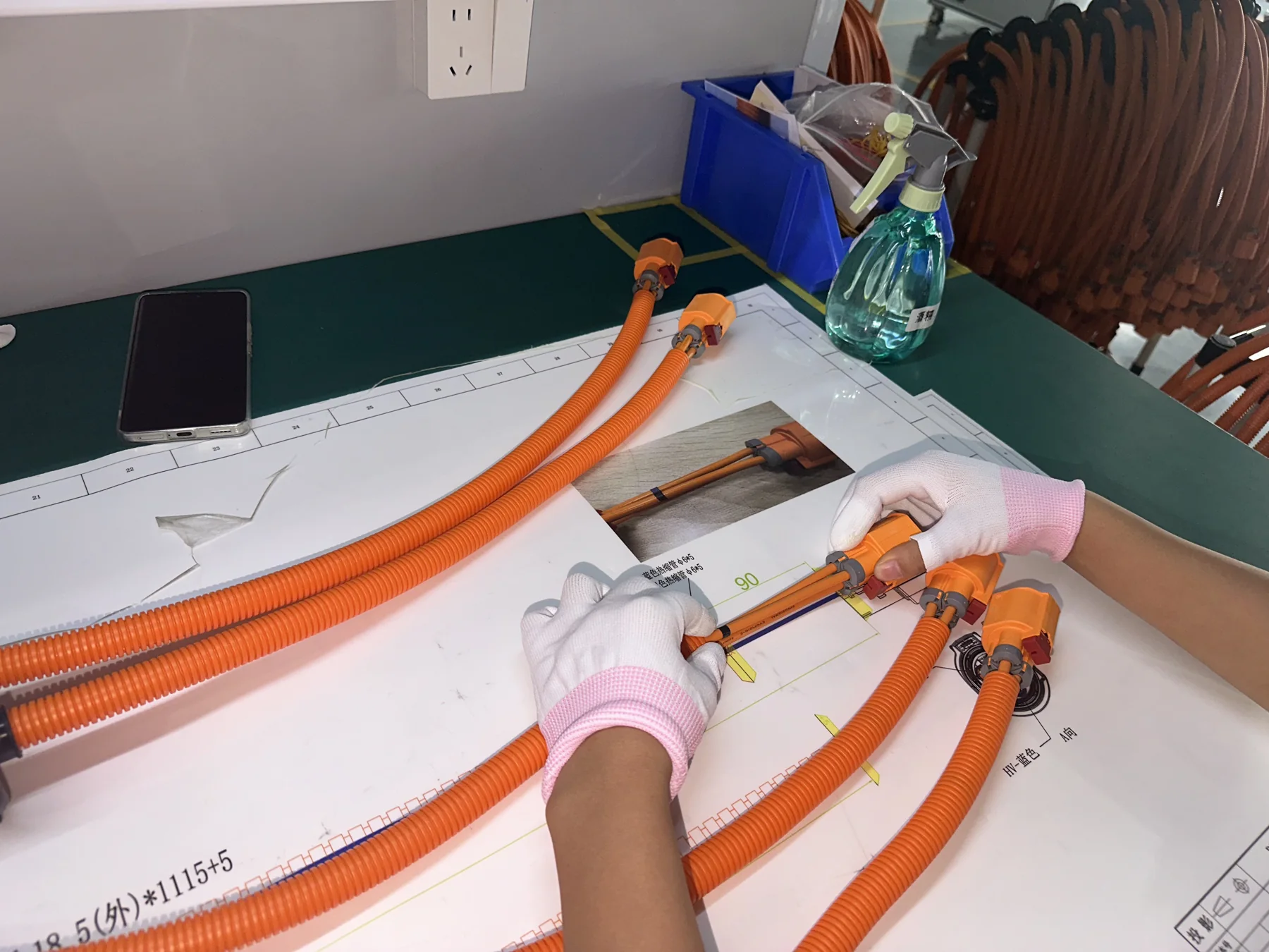 Operator preparing connectors and protective conduit during harness assembly